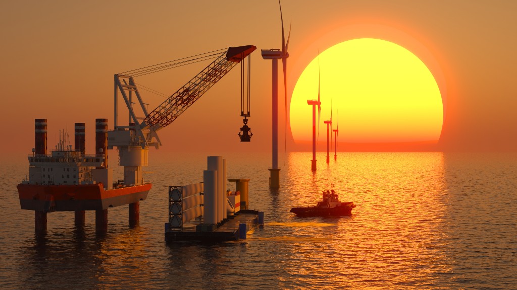 An offshore crane ship installs wind turbines at sea during sunset, with the sun low on the horizon, several wind turbines in the water, and a small boat nearby (OCS cable dutiability).